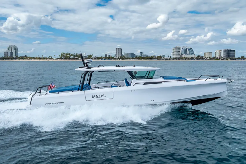 Slide: The Image of 2025 Axopar 45 Cross Top cruising on ocean near city skyline. - 17