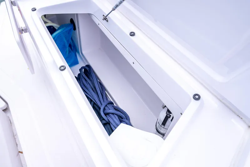 Slide: The Image of Storage compartment of 2025 Axopar 45 Cross Top boat with rope and equipment. - 20