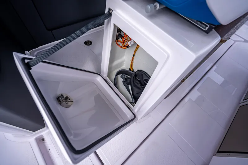 Slide: The Image of 2025 Axopar 45 Cross Top storage compartment with open hatch, showcasing interior details. - 21