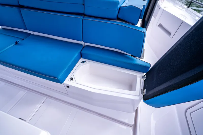 Slide: The Image of 2025 Axopar 45 Cross Top boat with blue seating and storage compartment. - 22
