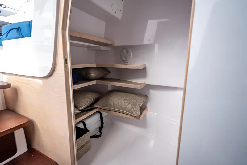 Slide: The Image of Interior storage space with shelves and cushions on the 2025 Axopar 45 Cross Top boat. - 25
