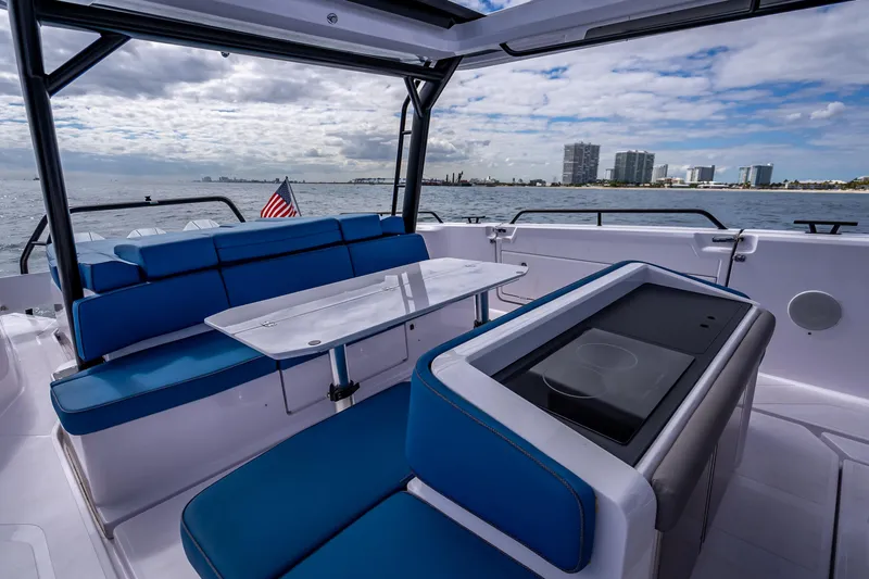 Slide: The Image of 2025 Axopar 45 Cross Top boat interior with blue seating and ocean view. - 34