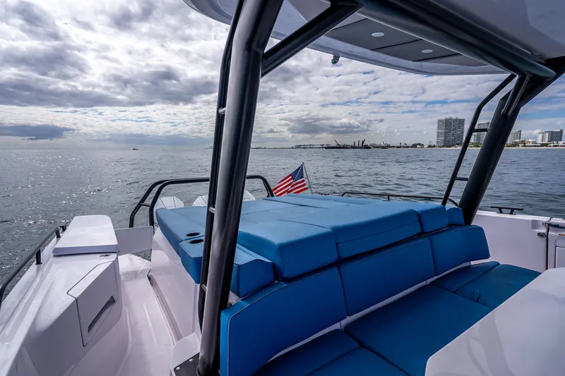 Slide: The Image of 2025 Axopar 45 Cross Top boat with blue seating, cruising on open water. - 35