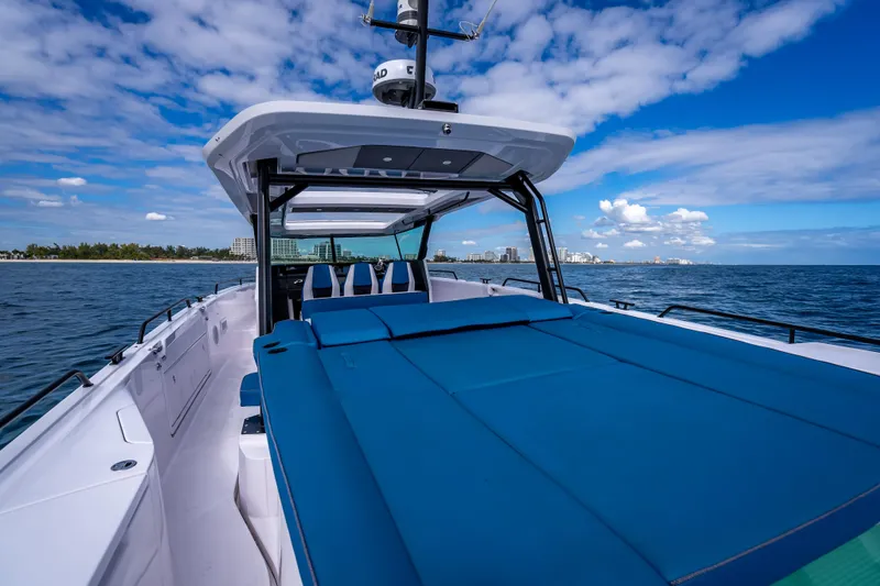 Slide: The Image of 2025 Axopar 45 Cross Top boat on open water under blue sky. - 36