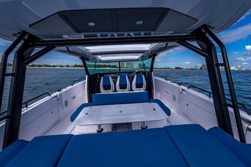 Slide: The Image of 2025 Axopar 45 Cross Top boat interior with blue seating and ocean view. - 37