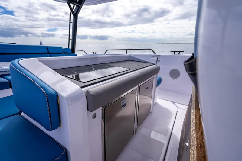 Slide: The Image of 2025 Axopar 45 Cross Top boat interior with sleek kitchen and blue seating. - 40