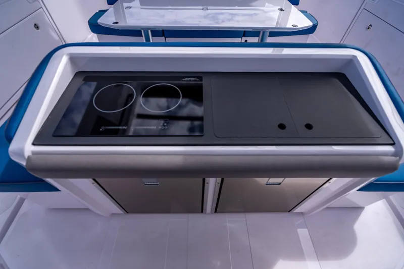 Slide: The Image of Modern kitchen area on 2025 Axopar 45 Cross Top boat, featuring sleek stovetop design. - 41