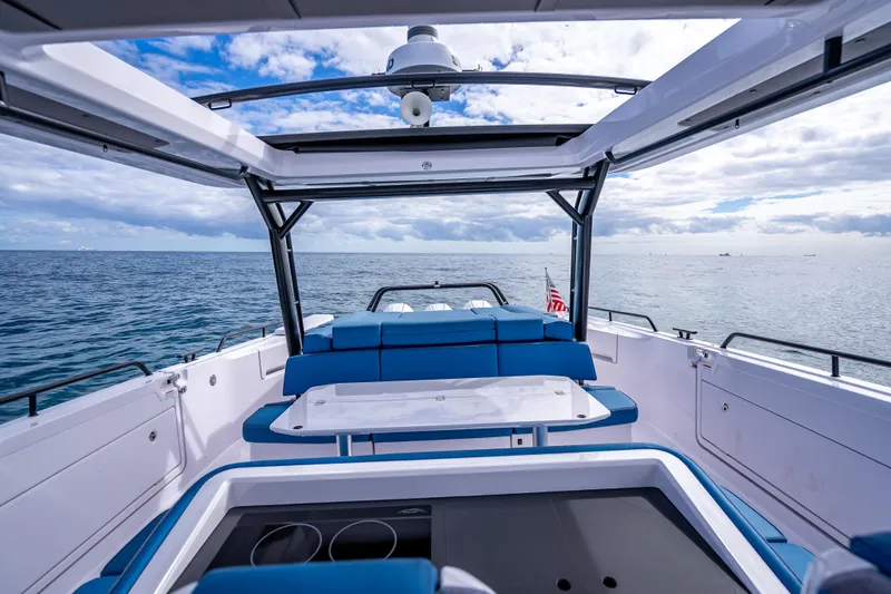Slide: The Image of 2025 Axopar 45 Cross Top boat interior with ocean view and blue seating. - 42