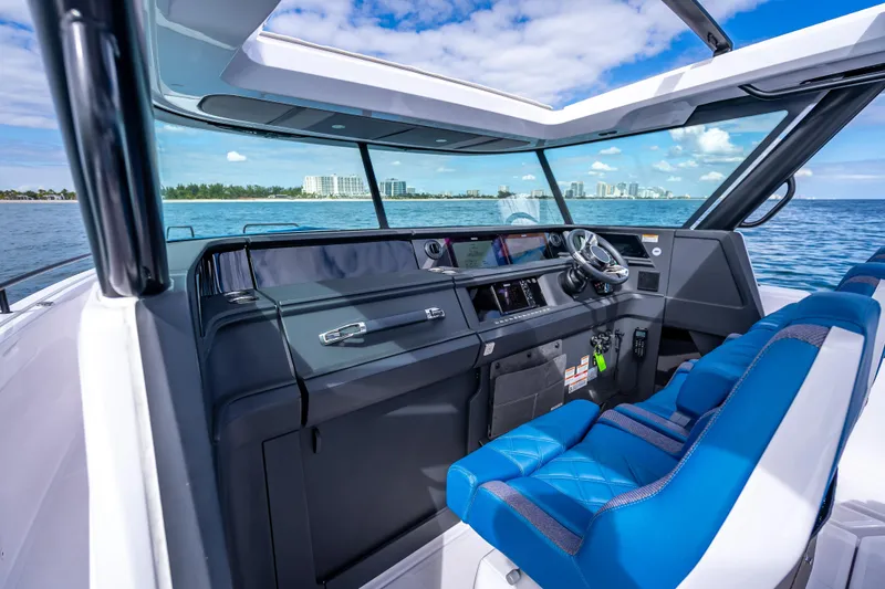 Slide: The Image of Interior view of 2025 Axopar 45 Cross Top boat with blue seating and modern dashboard. - 43