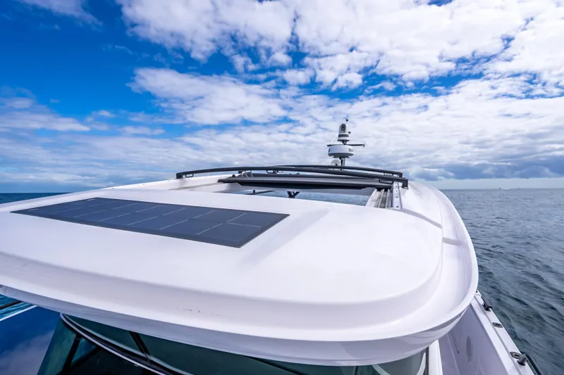 Slide: The Image of 2025 Axopar 45 Cross Top boat with solar panel under a blue sky. - 53