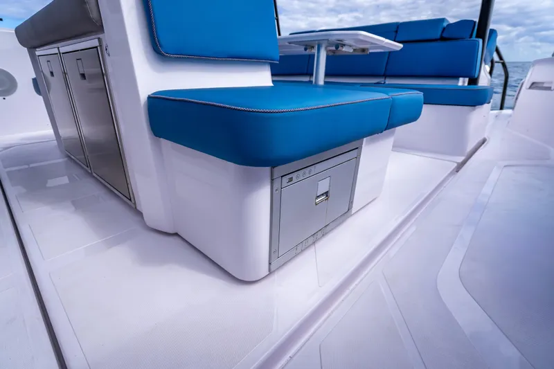 Slide: The Image of 2025 Axopar 45 Cross Top boat interior with blue seating and storage compartments. - 54