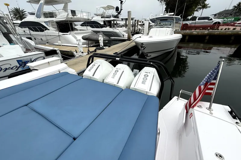 Slide: The Image of 2025 Axopar 45 Cross Top boat cruising on open water near city skyline. - 7