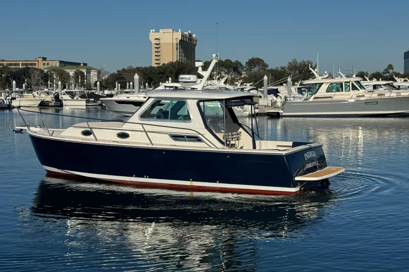 Slide: The Image of 2005 Back Cove 29 boat on calm water near a marina. - 19
