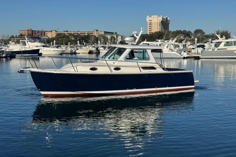Slide: The Image of 2005 Back Cove 29 boat docked in a marina, surrounded by other vessels. - 20
