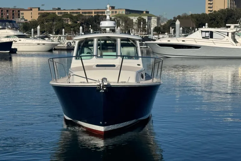 Slide: The Image of 2005 Back Cove 29 boat docked in a marina, surrounded by other vessels. - 23