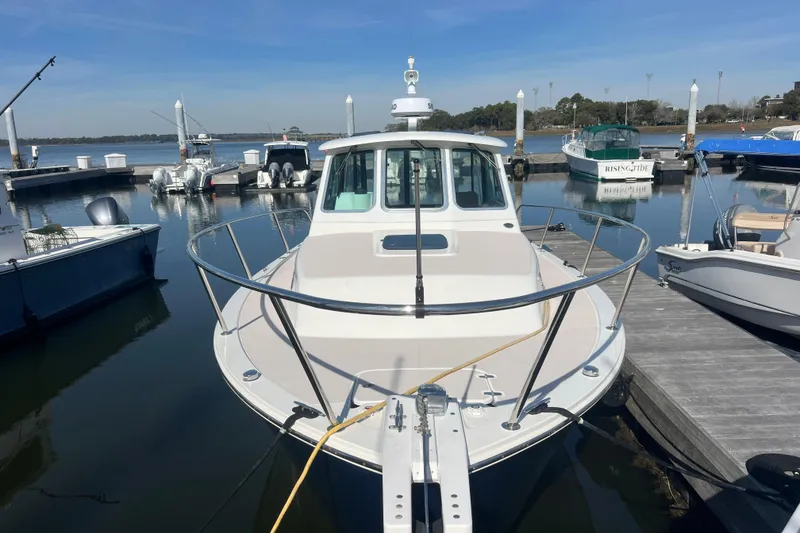 Slide: The Image of 2005 Back Cove 29 boat docked at a marina, surrounded by calm waters. - 24