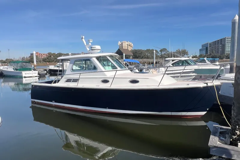 Slide: The Image of 2005 Back Cove 29 boat docked in a marina under clear blue skies. - 26
