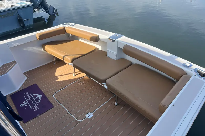 Slide: The Image of 2005 Back Cove 29 boat interior with brown cushioned seating and teak flooring. - 28