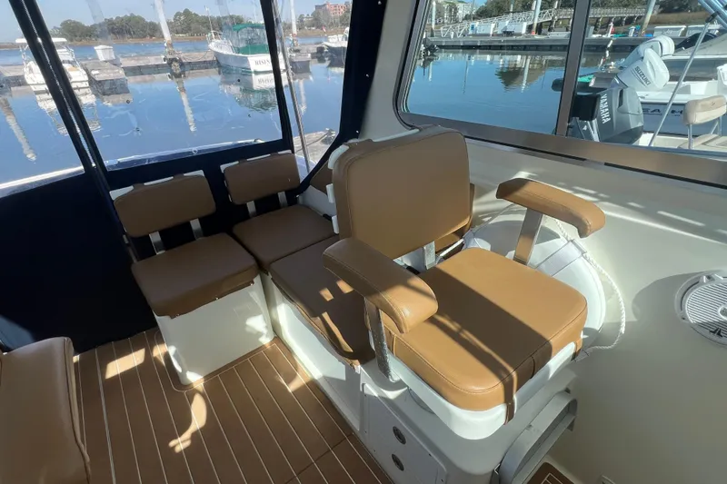 Slide: The Image of Interior of 2005 Back Cove 29 boat with tan seating and marina view. - 31