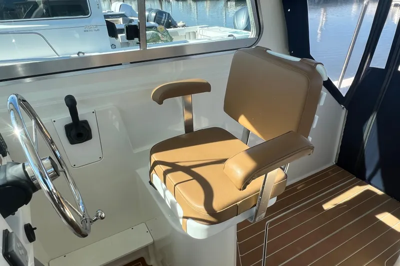 Slide: The Image of Captain's chair and helm in 2005 Back Cove 29 boat interior. - 32