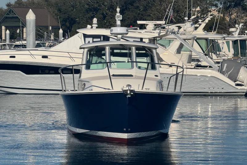 Slide: The Image of 2005 Back Cove 29 boat docked in a marina, surrounded by other vessels. - 4