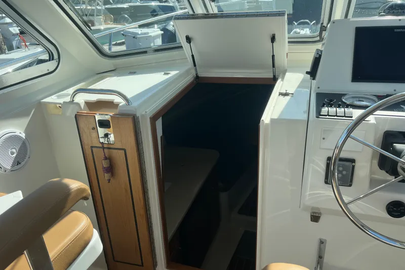 Slide: The Image of 2005 Back Cove 29 boat interior with helm, seating, and cabin entrance. - 43