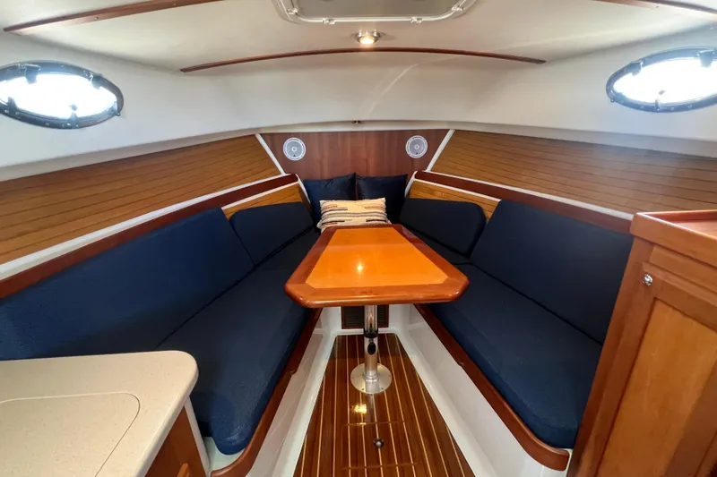 Slide: The Image of 2005 Back Cove 29 interior with blue seating, wooden table, and nautical decor. - 44