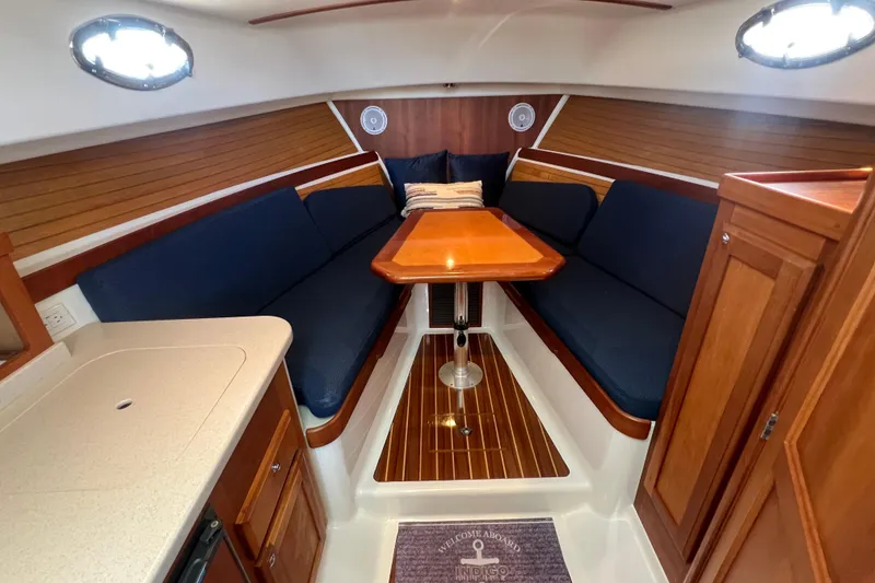 Slide: The Image of 2005 Back Cove 29 interior with wooden table, blue seating, and elegant cabinetry. - 45