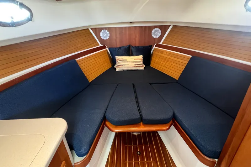 Slide: The Image of 2005 Back Cove 29 boat interior with blue cushions and wooden accents. - 49
