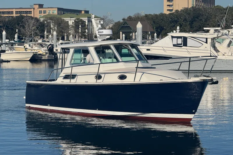 Slide: The Image of 2005 Back Cove 29 boat docked in a marina, surrounded by other vessels. - 5