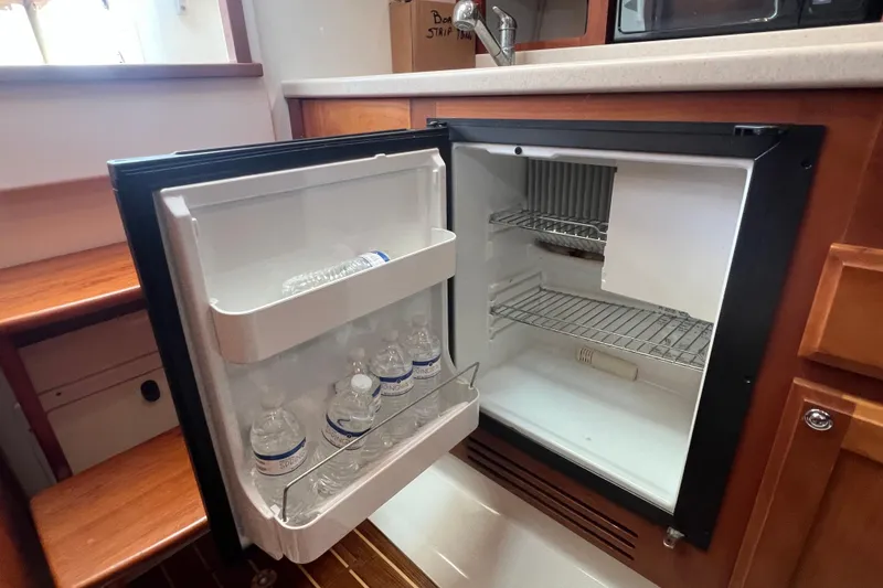 Slide: The Image of Open mini fridge with water bottles inside, aboard a 2005 Back Cove 29 boat. - 52