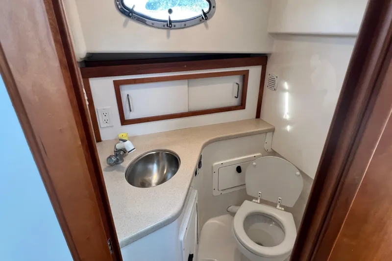 Slide: The Image of 2005 Back Cove 29 boat bathroom with sink, toilet, and storage cabinet. - 54
