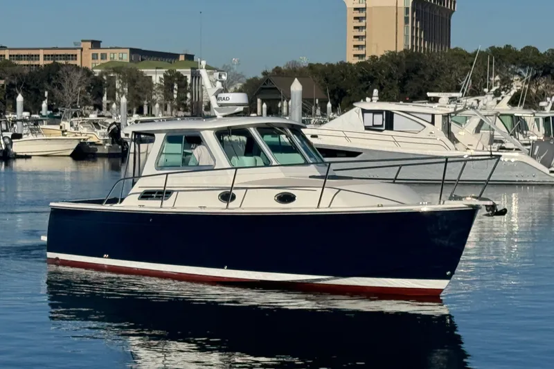 Slide: The Image of 2005 Back Cove 29 boat docked in a marina, surrounded by other vessels. - 6