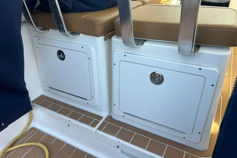 Slide: The Image of 2005 Back Cove 29 boat interior with storage compartments and cushioned seating. - 60