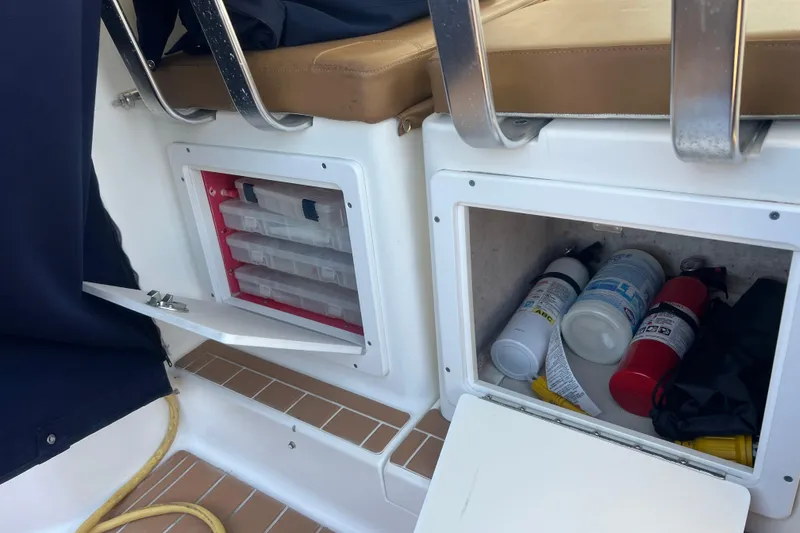 Slide: The Image of Storage compartments on a 2005 Back Cove 29 boat, featuring safety equipment and supplies. - 61