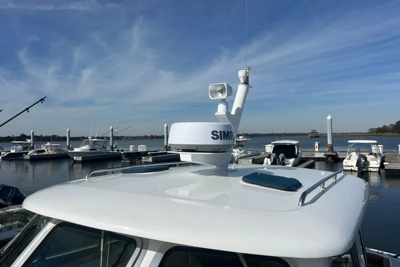 Slide: The Image of 2005 Back Cove 29 boat with radar, docked at marina under clear sky. - 66