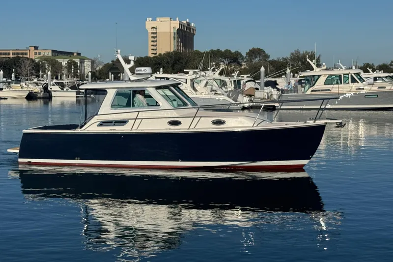 Slide: The Image of 2005 Back Cove 29 boat docked in a marina, reflecting on calm water. - 9