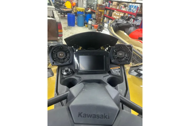 Slide: The Image of 2023 Kawasaki Jetski Ultra 310LX dashboard with speakers in a workshop setting. - 11