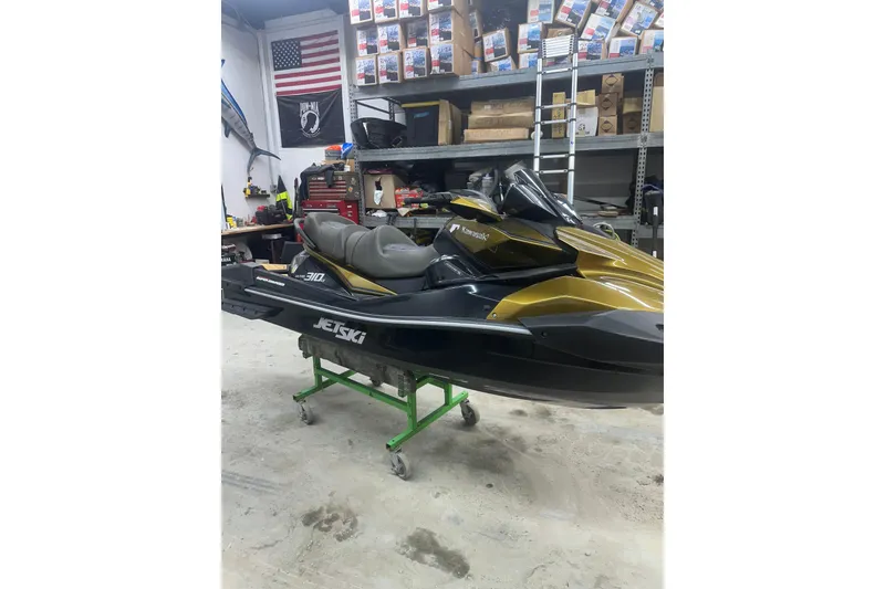 Slide: The Image of 2023 Kawasaki Jetski Ultra 310LX in a garage with tools and shelves. - 8