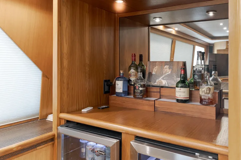Slide: The Image of 1997 Forbes Cooper Pilothouse yacht interior with a wooden bar and liquor display. - 13