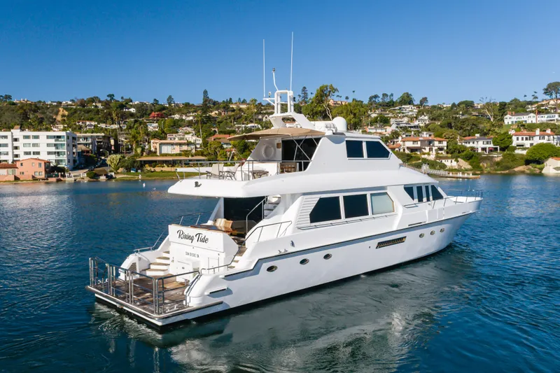Slide: The Image of 1997 Forbes Cooper Pilothouse yacht on serene water with coastal homes in the background. - 5