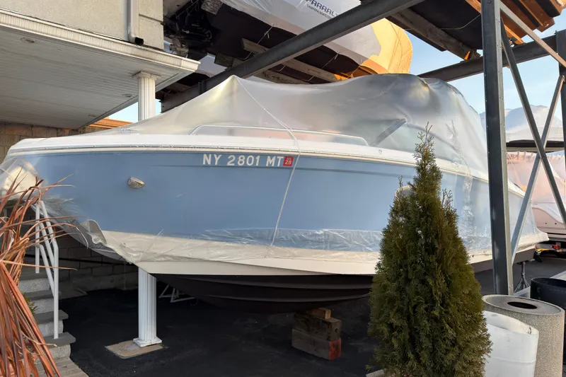 The Image of 2022 Chaparral 287 SSX boat covered in plastic, stored outdoors. - 1