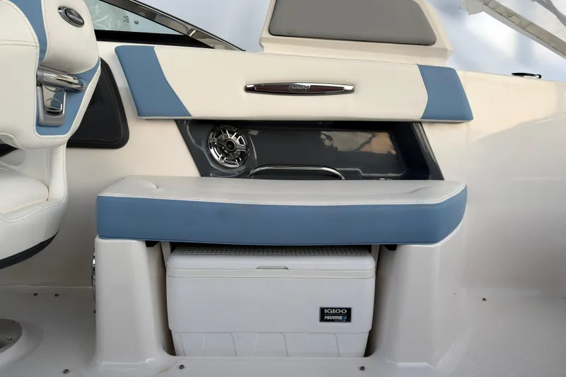 Slide: The Image of 2022 Chaparral 287 SSX boat interior with blue and white seating, featuring an Igloo cooler. - 13