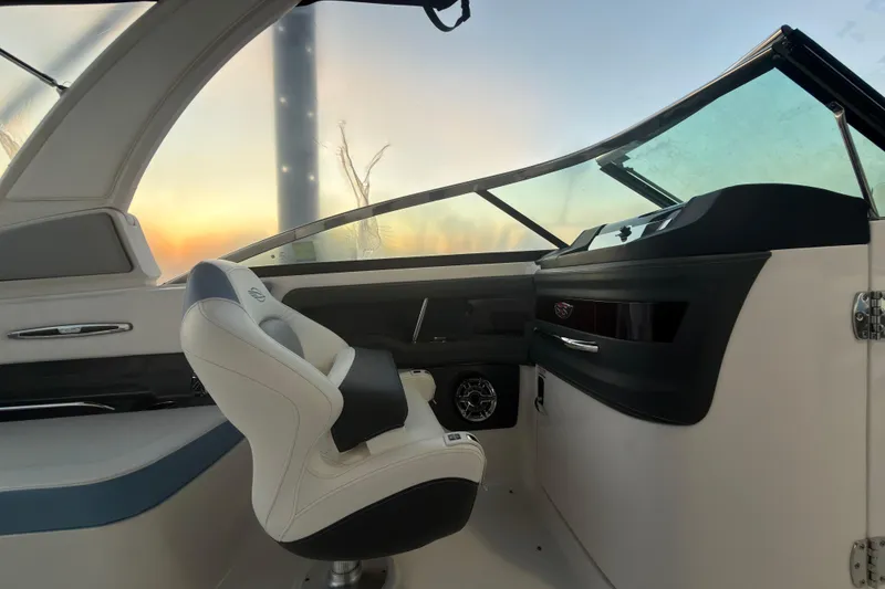 Slide: The Image of Interior of 2022 Chaparral 287 SSX boat at sunset, featuring helm and seating. - 20