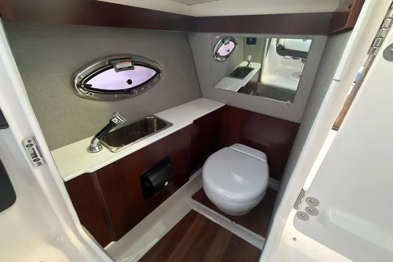 Slide: The Image of 2022 Chaparral 287 SSX boat bathroom with sink, toilet, and mirror. - 3