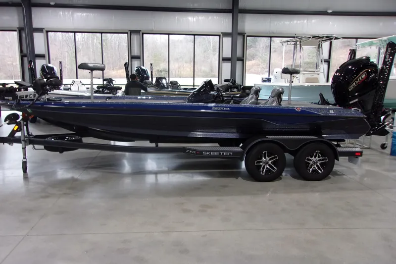 Slide: The Image of 2020 Skeeter ZXR21 boat in showroom, sleek design, dual-axle trailer. - 2