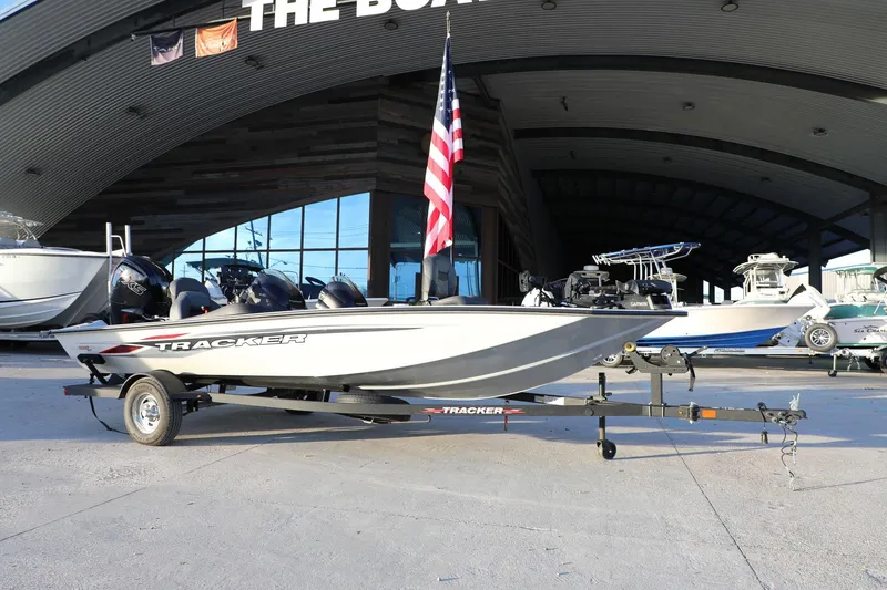 Slide: The Image of 2024 Bass Tracker Pro 19 boat on trailer, displayed outdoors with American flag. - 12