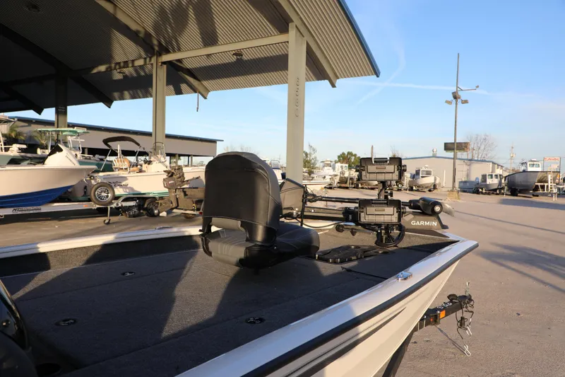 Slide: The Image of 2024 Bass Tracker PRO TEAM 190 boat with Garmin equipment, parked under a metal canopy. - 6