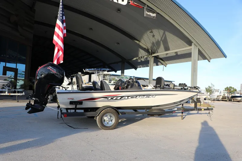 Slide: The Image of 2024 Bass Tracker Pro 19 boat displayed outdoors with American flag. - 10