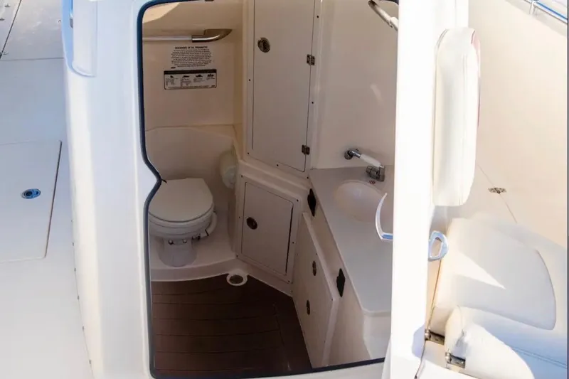 Slide: The Image of 2018 Cobia 320 Center Console boat interior with compact bathroom amenities. - 6